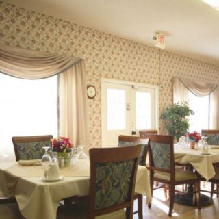 Cozy dining room with elegantly set tables and floral decor.