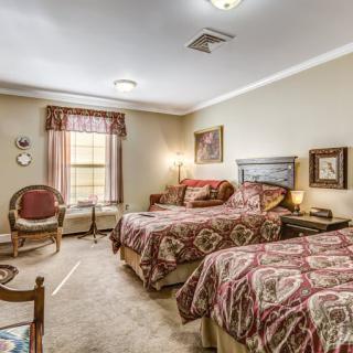 A traditional-style bedroom with two beds and elegant decor.
