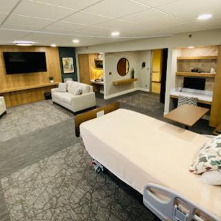 A spacious and modern hospital patient room designed for comfort and functionality.