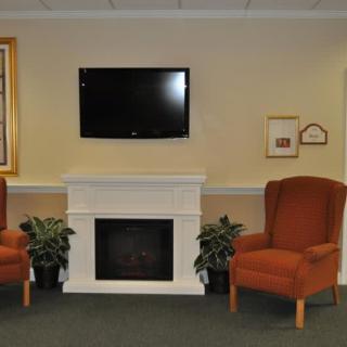 A cozy living room setup with a fireplace, television, and comfortable seating.