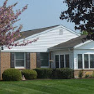 A charming residential house with a well-maintained lawn and garden.
