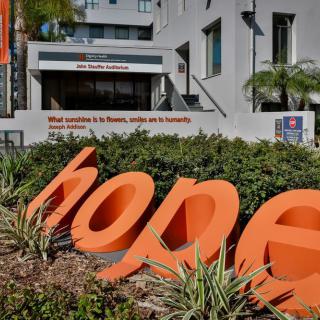 A large 'hope' sign in front of a modern building.