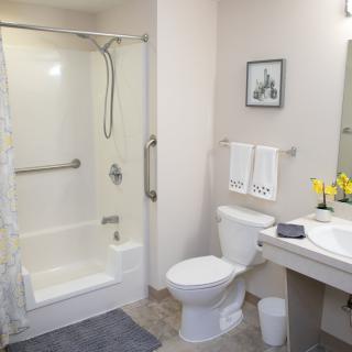 A clean and modern bathroom featuring a shower, toilet, and sink.