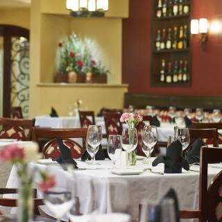 Elegant restaurant interior with neatly arranged tables and wine display.