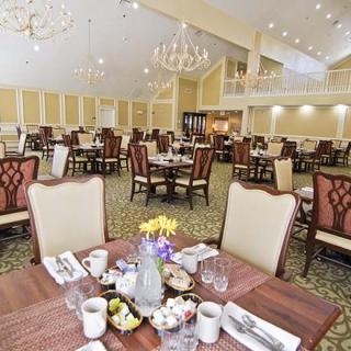 An elegant dining hall with neatly arranged tables and chandeliers.