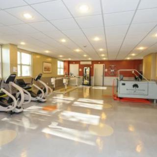 A well-lit gym with modern exercise equipment and spacious layout.