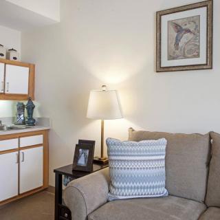A cozy living room corner with a sofa, lamp, and wall art.
