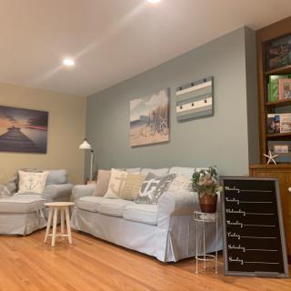 A cozy living room with comfortable seating, decorative wall art, and a touch of greenery.