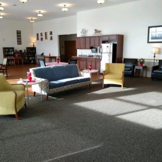 A spacious living area with sofas and chairs facing a kitchen space.