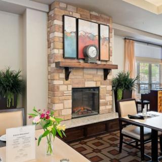 A cozy dining area featuring a brick fireplace, elegant decor, and comfortable seating.