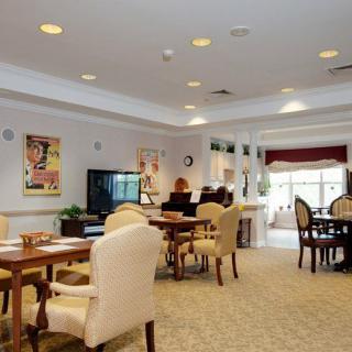 A cozy dining area with tables and chairs in a senior living facility.