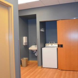 A modern laundry room with a washer, sink, and blue walls.