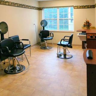 An empty hair salon with chairs and dryers arranged neatly.