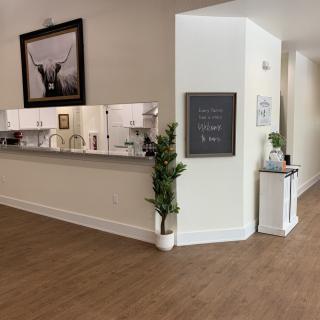 A modern reception area with a desk, plants, and artwork on the walls.