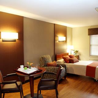 A cozy hotel room featuring a comfortable bed, seating area, and modern lighting.