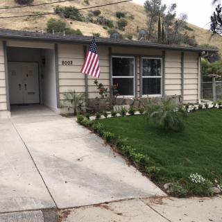 A small residential house with an American flag displayed in the front yard.