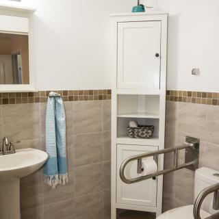 A well-organized bathroom with a sink, cabinet, and accessibility features.
