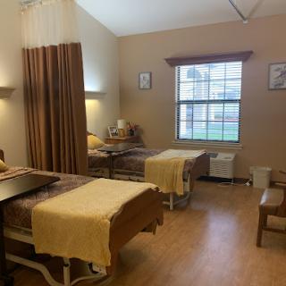 A well-lit hospital room featuring two beds, suitable for patient care.