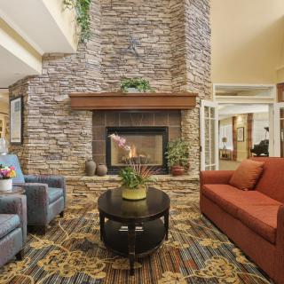 A cozy living room with a stone fireplace and comfortable seating.