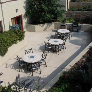 An outdoor patio area with several tables and chairs arranged for seating.