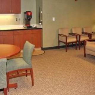A cozy waiting room with seating and a coffee station.
