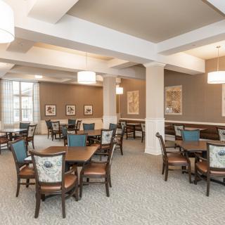 A well-lit dining area with multiple tables and chairs, featuring elegant decor.