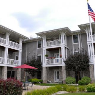 A modern apartment building with balconies and a well-maintained garden.