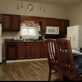 A cozy kitchen with wooden cabinets and a dining area featuring a table and chairs.