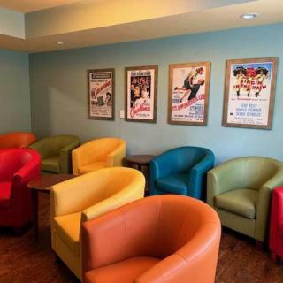 A colorful waiting room with a variety of chairs and framed posters on the wall.