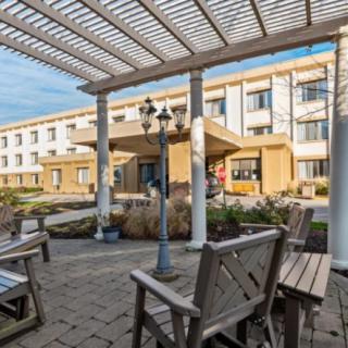 Outdoor seating area in front of a modern hotel building.