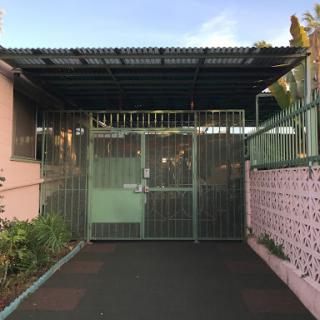 A gated entrance to a building, surrounded by a decorative wall.