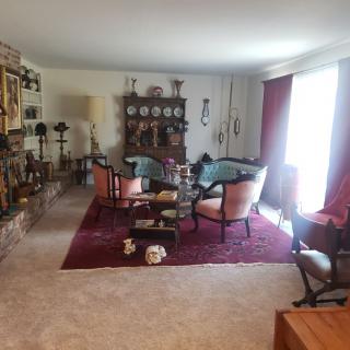 A vintage-styled living room with classic furniture and a china cabinet.
