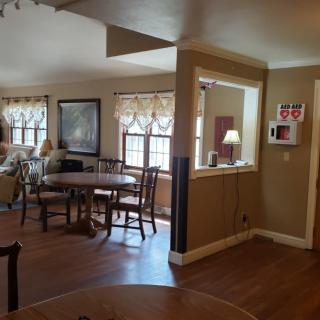 A cozy dining and living area with wood flooring and ample natural light.