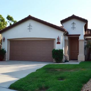 A suburban house with a two-car garage and well-maintained lawn.