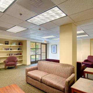 A comfortable office space with seating area and bookshelves.