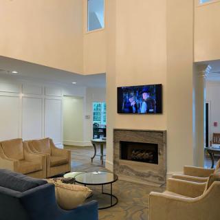 A spacious modern living room with comfortable seating, a fireplace, and a wall-mounted television.