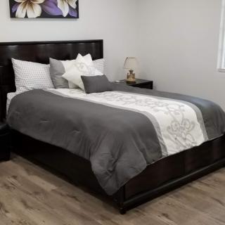 A neatly arranged bedroom with a stylish bed and elegant decor.