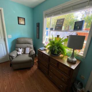 Cozy living room corner with an armchair and a window-side dresser.