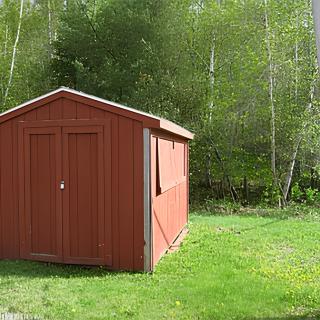 A wooden shed surrounded by lush greenery and a grassy lawn.