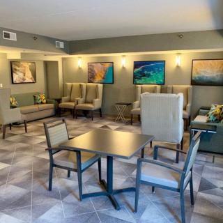 A comfortable lounge area with various seating options and decorative artwork on the walls.