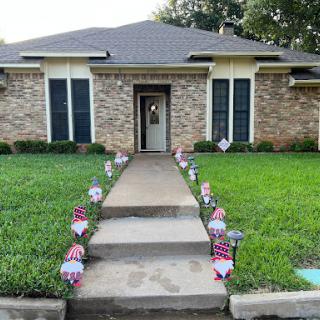 A charming home with a neatly landscaped front yard, featuring decorative garden gnomes along the walkway.