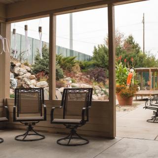 A cozy patio with swivel chairs overlooking a landscaped garden.