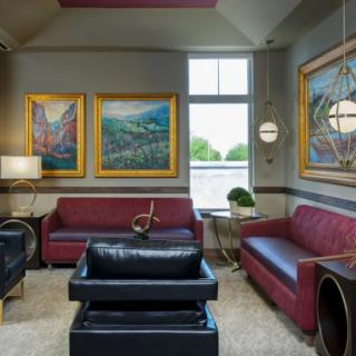 A stylish living room with modern furniture and colorful artwork on the walls.