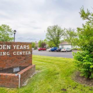 Entrance sign of a nursing center surrounded by greenery and a parking lot.