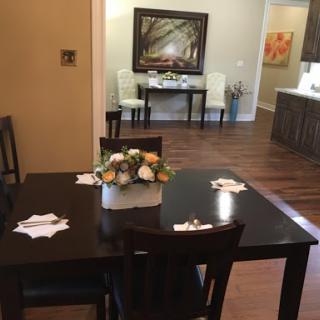 A cozy dining area featuring a beautifully set table with a floral centerpiece.