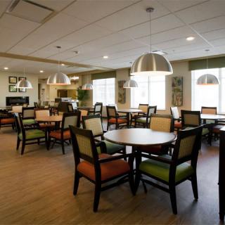 A spacious dining area with tables and chairs, well-lit by modern pendant lights.