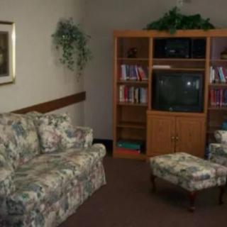 A cozy living room with floral upholstered furniture and a classic wooden entertainment center.