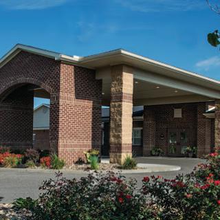 The welcoming entrance of a hotel surrounded by vibrant landscaping.