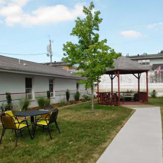 A peaceful outdoor area featuring a gazebo, seating, and greenery.