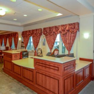 Hotel reception area with a check-in desk and decorative curtains.